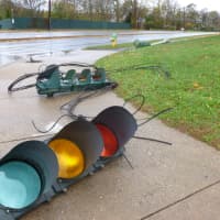 <p>Three traffic lights at the White Plains High School entrance lay on the ground.</p>