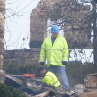 <p>Crews go through the wreckage of one of the burned houses on Binney Lane in Old Greenwich.</p>