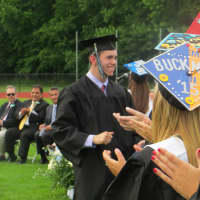 <p>A Rye Neck High graduate being congratulated by classmates after receiving his diploma.</p>