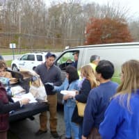 <p>Sen. Greg Ball, center, helps distribute dry ice and water at the Lewisboro Town House on Tuesday as Town Clerk Janet Donohue, far left, looks on.</p>