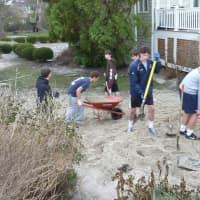 <p>Staples High School soccer players work to remove sand from the front yard of teammate Sebo Hood&#x27;s home on Soundview Drive near Compo Beach in Westport on Wednesday afternoon.</p>