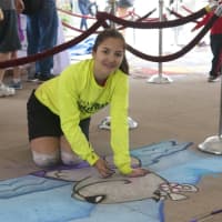 <p>Nancy Haack, of Naugatuck, works on her chalk art piece at Saturday&#x27;s festival at the Cross County Shopping Center.</p>