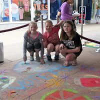 <p>From L: Sarah Laverty, Kiki Manuguerra and Sive Hourigan, of Woodlawn, show their chalk art work.</p>