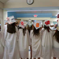 <p>Members of the Class of 2015 showcase their mortarboard designs.</p>