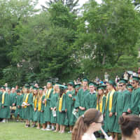 <p>The Class of 2015 stands to receive diplomas.</p>
