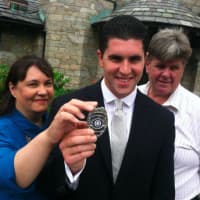 <p>New Officer William Sheehan holding his New Canaan Police Department badge with his parents Patrice and William Sr.</p>