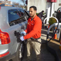 <p>Shell employee Sam Lorenzo fills up one of the many cars that came through the Harrison station on Monday.</p>