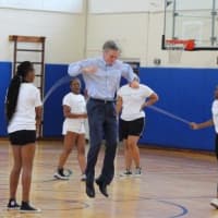 <p>White Plains Mayor Thomas Roach takes a turn jumping on Thursday at Ridgeway Elementary School.</p>