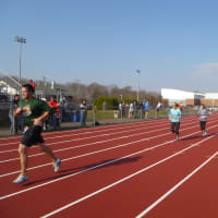 <p>Runners finish the Reservoir Run on the Weston High School track.</p>