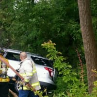 <p>Firefighters doused flames coming from the engine of an SUV that crashed in Greenburgh along the Sprain Brook Parkway about 4:10 p.m. Thursday. A Westchester County police officer is credited with saving the driver&#x27;s life before the SUV caught fire.</p>