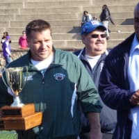 <p>Rippowam coach Gary Bivona accepts the junior varsity championship trophy from Will Poole, a former NFL player who attended Sunday&#x27;s games.</p>