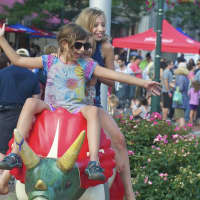 <p>Three young girls pose for a photo on one of the many dinosaurs around Stamford, as part of one of the street art project.</p>