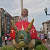 <p>A girl rides one of the dinosaurs around Columbus Park.</p>