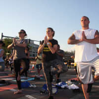 <p>White Plains Police Officer Tara Altamuro (left) practices yoga with two Tuckahoe police officers at an outdoor yoga event. </p>