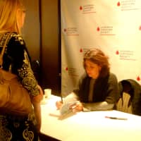 <p>Author Jane Green signs one of her books for a luncheon guest. </p>