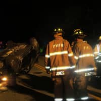 <p>The front of the flipped car as Putnam Valley firefighters examine the crash scene.</p>