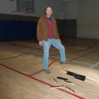 <p>Scott Smith, communications director at the Westport Weston Family Y, stand in the Y&#x27;s Lower Gym, where flood waters caused the wood floor to buckle. </p>