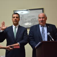 <p>Edward Brancati (center) is sworn in as Mount Kisco Village Manager, with Mayor Michael Cindrich (right) giving the oath. </p>