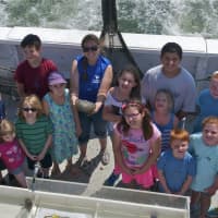 <p>Children on a study cruise pose with one of the cruise instructors and a horseshoe crab that was pulled up during the cruise.</p>