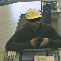 <p>The suspect presenting a note presumably demanding cash during Saturday&#x27;s Scarsdale bank robbery.</p>