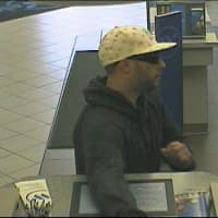 <p>The suspect in Saturday&#x27;s bank robbery in Scarsdale passing the teller a note.</p>