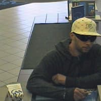 <p>The suspect in Saturday&#x27;s bank robbery in Scarsdale passing the teller a note.</p>
