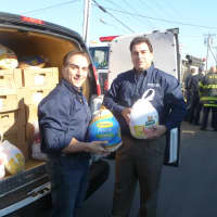 <p>Rich Cunningham (right), owner of Ed&#x27;s Garage Doors, loads turkeys donated by local residents during his Norwalk food drive into a delivery truck.</p>