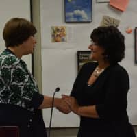 <p>Jennifer Gerken shakes hands with District Clerk Carole LaColla following the oath of office for school board president.</p>