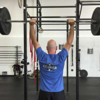 <p>CrossFit General Manager Tim Deenihan demonstrates a lift at the gym Tuesday.</p>
