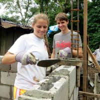 <p>Third-time trip participant and recent Mamaroneck High School graduate Freya Cantwell and second-time trip participant and rising Mamaroneck High School senior Axel Steinmetz build the walls of the house.</p>