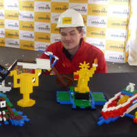 <p>Michael Tocidlowski poses with his Lego models after being crowned Master Model Builder Sunday at Ridge Hill. </p>