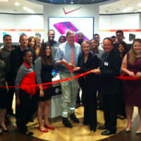 <p>Mayor David Martin, center, prepares to cut the ribbon at the expanded Verizon Wireless store at Stamford Town Center.</p>