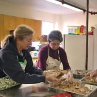 <p>Volunteers in the kitchen prepared turkey for serving.</p>