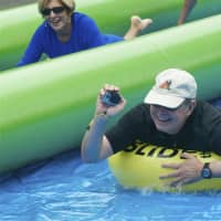 <p>Stamford Mayor David Martin shoots with a Go Pro as he slides.</p>