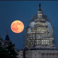 <p>The blue moon next to the dome of the U.S. Capitol on Friday.</p>