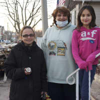 <p>Claire Tenney, right, of Stamford, stands with a pair of women from Staten Island, N.Y. whose homes were damaged by Hurricane Sandy. One of them is holding a flashlight that Claire gave them. </p>