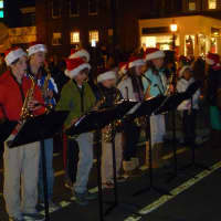 <p>Saxe Middle School students play holiday tunes on their saxophones under the direction of Chris Coulter, right. </p>