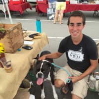 <p>Farmers Market staffer Ronan May poses with a dog left in his charge.</p>