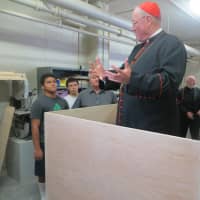 <p>Cardinal Timothy Dolan steps up into the partially built pulpit that Pope Francis will speak from at Madison Square Garden on Sept. 25. &quot;They give the height of the Pope and the width of the Cardinal,&#x27;&#x27; Dolan joked of the pulpit&#x27;s measurements.</p>