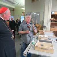 <p>Bill Kelley, wood shop teacher at Lincoln Hall Boys&#x27; Haven in Somers, describes how a biscuit joiner is used to put pieces of wood together on Thursday. &quot;I know what biscuits and gravy are,&#x27;&#x27; joked Cardinal Timothy Dolan.</p>