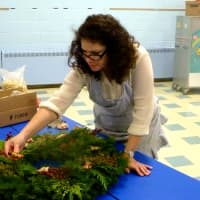 <p>Marguerite Hajjar works on her first wreath in the Doors of Shippan contest in Stamford.</p>