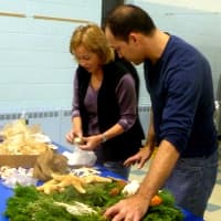 <p>Floral designer Iris Oliveira helps Marty Cokin with her seashore themed wreath. </p>