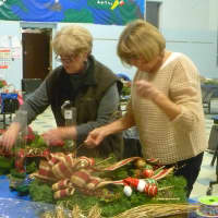 <p>Ginny Fox (left) and Ricki Miller help each other with their wreaths. </p>