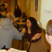 <p>Armonk resident Geri Mariano shakes the hands of Seven Bridges Middle School students after her presentation.</p>