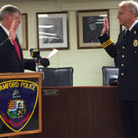 <p>Mayor David Martin swears in Tom Wuennemann as the new Assistant Chief of the Stamford Police Department on Wednesday.</p>