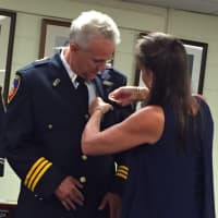 <p>New Assistant Chief of Stamford Police Tom Wuennemann watches as his wife Jamie pins his badge on during the swearing in ceremony Wednesday. </p>
