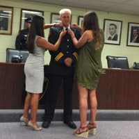 <p>Stamford&#x27;s new Assistant Chief of Police Tom Wuennemann watches as his daughters, Lauren, 24, left, and Marissa, 22, pin him during his swearing in ceremony Wednesday.</p>