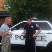 <p>Neil Davis checks his route with a Danbury police officer before he begins his walk through the city. </p>