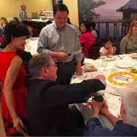 <p>As owner Ivy Bacher looks on Mayor David Martin uncorks a champagne bottle while state Rep. William Tong  prepares to cut the cake at the grand opening of the Pearl East Restaurant. </p>
