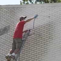 <p>Volunteers paint the exterior of the Allen Temple AME Church in Mount Vernon. </p>